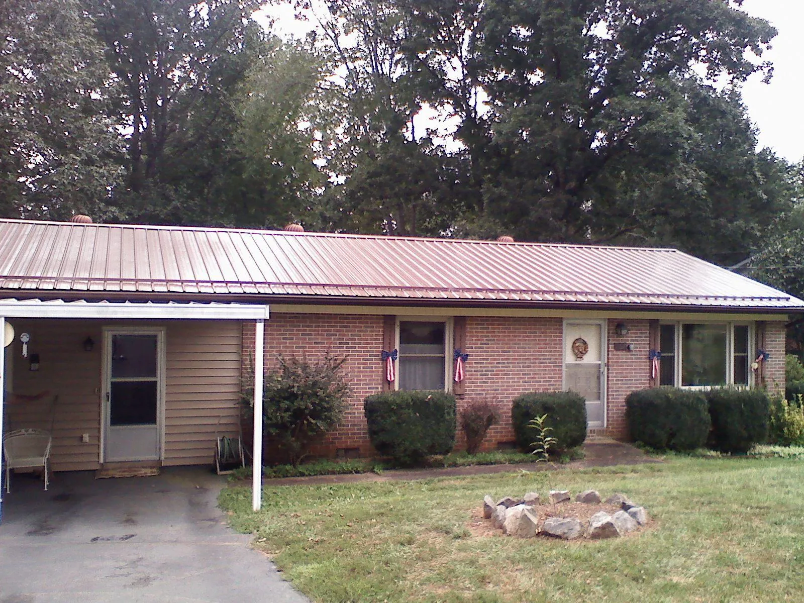 Bronze metal roof and carport on a brick ranch home — Roof Repair work by our crew in Himrod